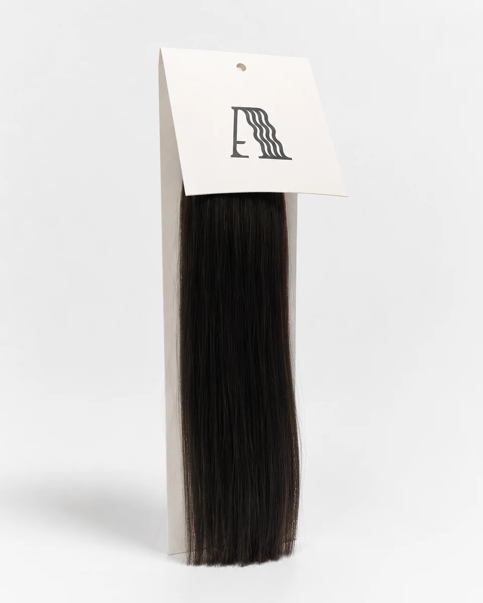 Stand-up Alpha Hair display card with slanted top panel holding a hanging bundle of hair extensions