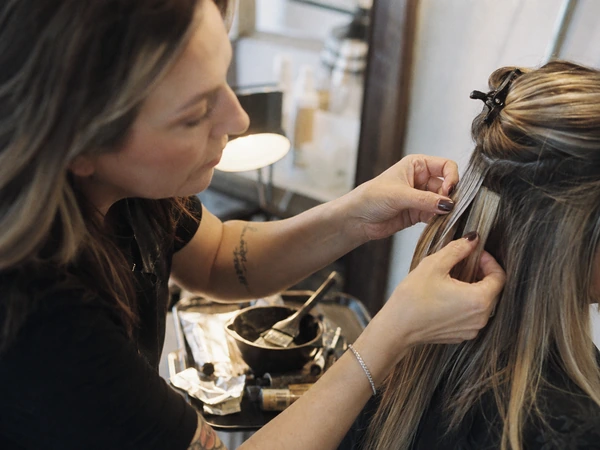 wholesale-salons 58 Master colorist at a premium German salon sectioning a client's hair for a custom color service, with color bowl, brush and foil at her station
